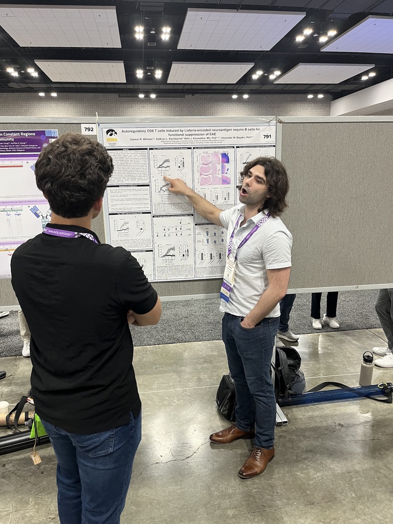 Connor pointing at a research poster